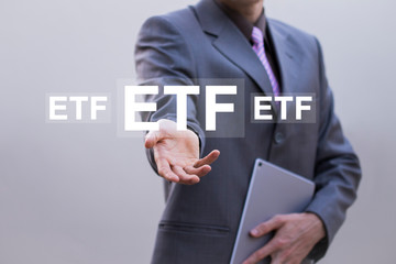 Businessman pressing button etf Exchange Traded Fund on a virtual interface.