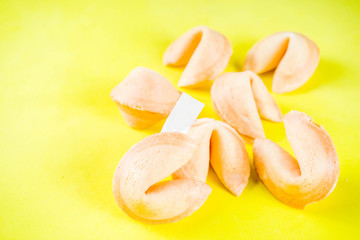 Naklejka na ściany i meble Chinese fortune cookie with prediction on bright yellow background top view copy space