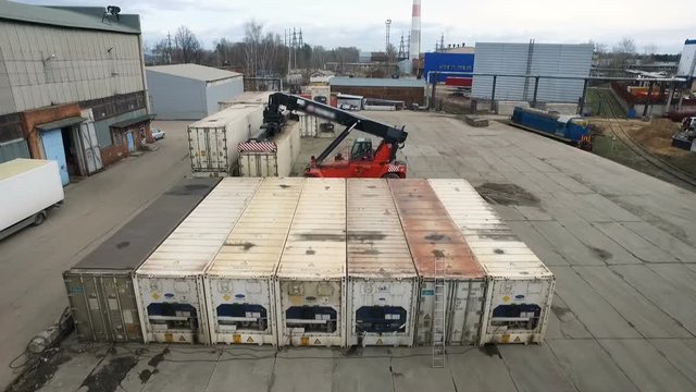 The lift lifts the metal container. Warehouse Russia quadcopter view. Moskow, Russia, 03.03.2018
