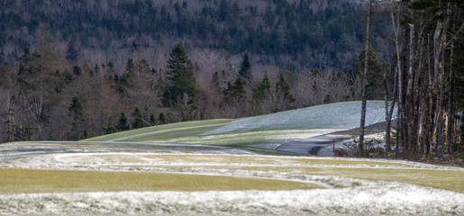 Light dusting of snow of golf green in winter, no people.