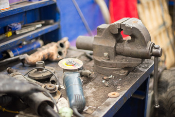 Metal workshop. Vise and bench grinder on metallic workbench. Copy space. grinder and clamp.