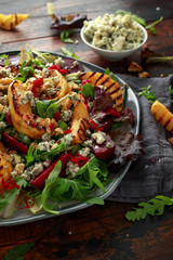 Grilled quince salad with baked and fresh grated beetroot, blue cheese, walnuts on wooden rustic table