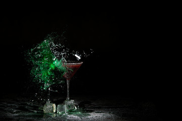 The breaking of a glass with fragments. The explosion of a glass on a black background with a...