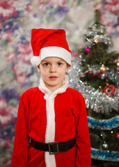 Kid as Santa claus decorating Christmas tree. New year small boy at decoration toy.