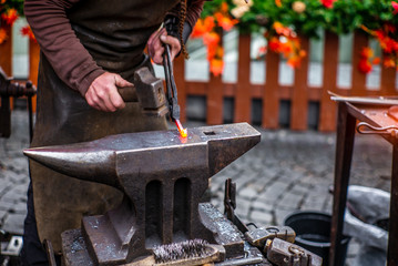 A blacksmith hammering a red hot horse nail at s Czech Christmas market in Prague  - 7
