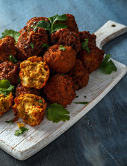 Indian Pakora snack spicy onion, red pepper with chilli sauce on white wooden board
