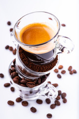 glass cups, in sequence vertically, with coffee beans, ground, and creamy drink. still life