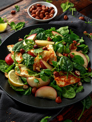 Grilled Halloumi Cheese salad with peach fruit, nuts and spinach, arugula mix. healthy food