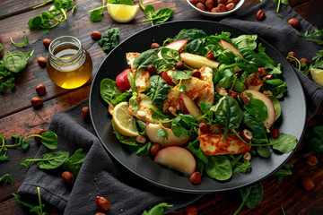 Grilled Halloumi Cheese salad with peach fruit, nuts and spinach, arugula mix. healthy food