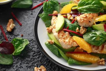 Grilled chicken with orange and avocado salad on rustic background