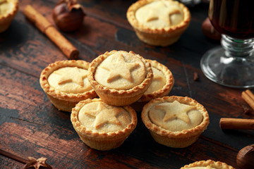 British Christmas mince pies with decoration, gifts, green tree branch on wooden rustic table