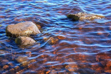 Large stones in the water of the lake near the shore