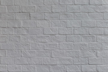 The white wall is made of  bricks and cement coated with gray color.