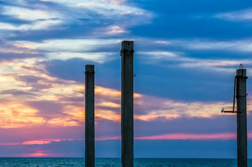 Ferroconcrete pillars against a background of a scenic sunset