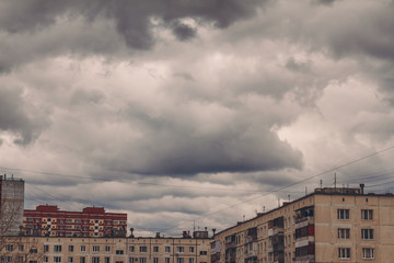 Dark, gloomy overcast sky over buildings in city during thunderstorm