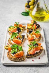 Olives cherry tomatoes goat cheese bruschetta. Selective focus, space for text.
