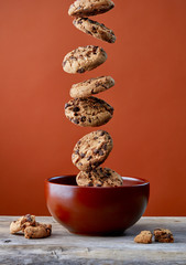 Chocolate chip cookies falling in bowl