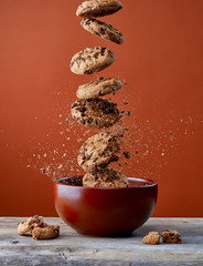 Chocolate chip cookies falling in bowl
