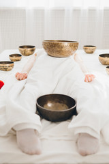 Girl doing massage therapy singing bowls in the Spa