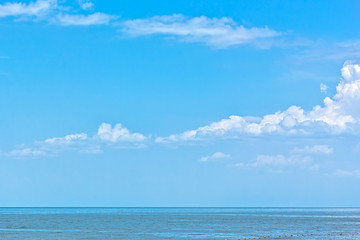 Obraz premium Białe puszyste chmury nad błękitnym morzem