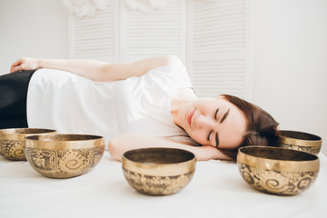 Girl doing massage therapy singing bowls in the Spa