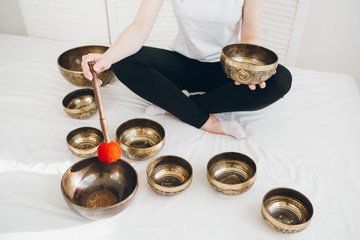 Massage therapist plays on singing bowls for a vibrational massa