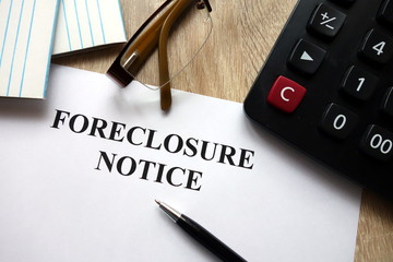 Foreclosure notice with pen, calculator and   glasses in office