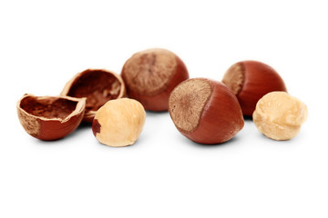 Hazelnuts and brown hazel leaves on white background, isolated, closeup