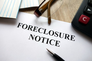 Foreclosure notice with pen, calculator and   glasses in office