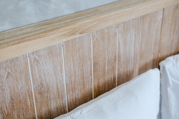 Light wooden bedhead and gray concrete wall, Loft interior design details, selective focus