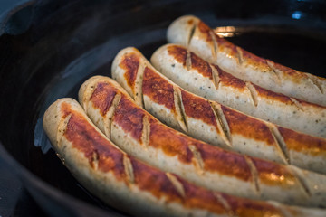 leckere bratwürste in gusseiserner Bratpfanne