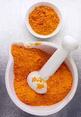 GROUND TUMERIC OR HALDI IN PESTLE AND MORTAR