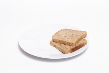 Fototapeta na wymiar Full grain bread slices on a white dish against white background