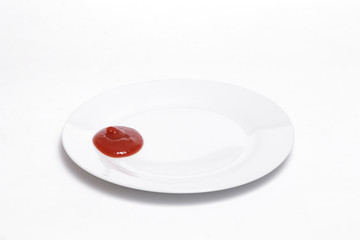Ketchup on a white dish against white background