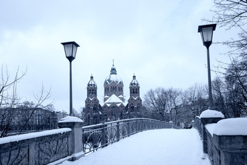 Kabelsteg Brücke über die Isar, zwei Laternen und Blick zur Lukaskirche