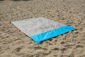 Waterproof and sandproof nylon beach blanket on sand. Very thin tarp or footprint used for outdoor...