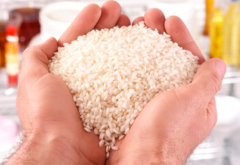 MAN 'S HANDS WITH HANDFUL OF ARBORIO RICE