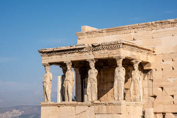 The ancient Erechtheion temple with the beautiful Caryatid pillars on the porch, on the Acropolis in Athens, Greece.