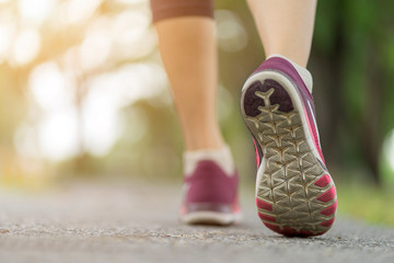 Naklejka premium Close up woman shoe running on the road, jogging alone at park, Sports healthy lifestyle concept.
