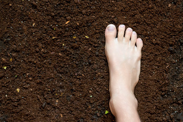 bare foot step on the dark soil, healthy concept f