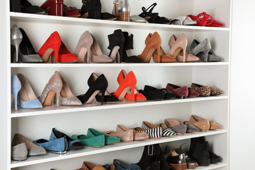 Shelving unit with different shoes. Element of dressing room interior