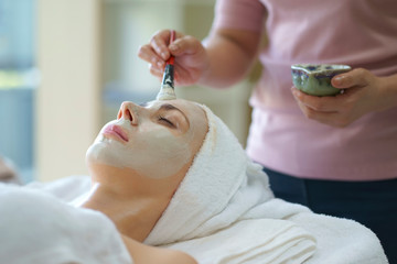 Beautiful caucasian woman having mask, lying on spa. Facial treatment in Spa salon.