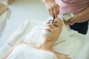 Fototapeta na wymiar Beautiful caucasian woman having mask, lying on spa. Facial treatment in Spa salon.