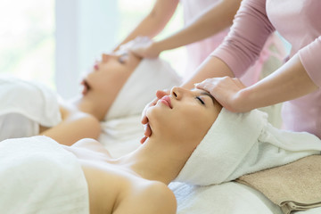 Obraz na płótnie Canvas Beautiful caucasian women relaxation and lying with massage on face in spa salon.