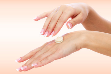 Well-groomed female hands with a cream on one of them. Skin care concept