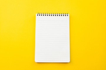 empty paper of notebook on yellow background with school concept.