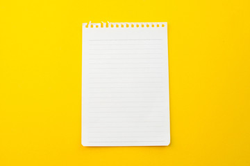 empty paper of notebook on yellow background with school concept.