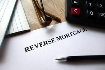 Reverse mortgage document with pen, calculator and   glasses on desk