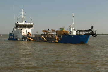 Dredger for absorption of trailer bunker during work on land reclamation for new ports. Suction dredge. Dredging in fairway of Dinai River. Cutter suction dredgers when working on land reclamation