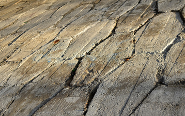 Wall or floor blocks made of asymmetrical stone. Diamond shaped concrete slabs, gray mosaic tiles